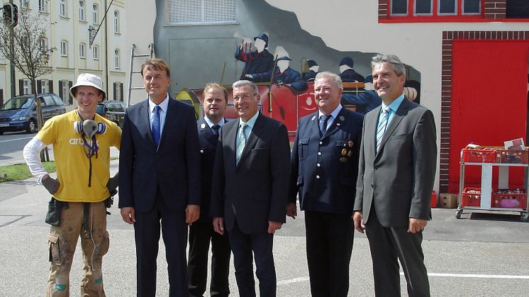 Künstler Markus Ronge, Bayernwerk-Regionalleiter Martin Hanner, 1. Kommandant Rudolf Brandhuber, Neuöttings Bürgermeister Peter Haugeneder, 1. Vorstand Josef Putz und Kommunalbetreuer Franz-Josef Bloier (v. l. n. r.) freuen sich über die Trafokunst.