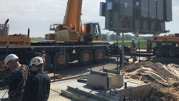 Der 32-Tonnen-Trafo wird vom Schwertransporter per Lastkran auf das neue Fundament gesetzt.