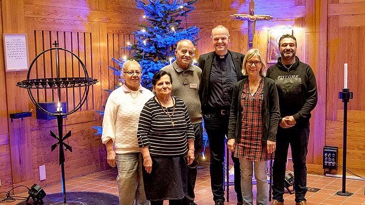 ”Välkommen till Bergsjöns kyrka”, säger volontärerna Ghazalen Razko, Samira Isak, Abu Fadi och Arash Ahmadi tillsammans med församlingen kantor Monika Stenow och församlingsherde Henrik Törnqvist. Den 13 december har kyrkan jul- och luciakonsert.