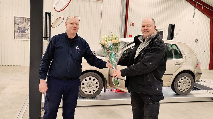 Bilprovningen firar sin nyöppnade station på Ekerö med att ge blommor till den första kunden. Foto: Bilprovningen