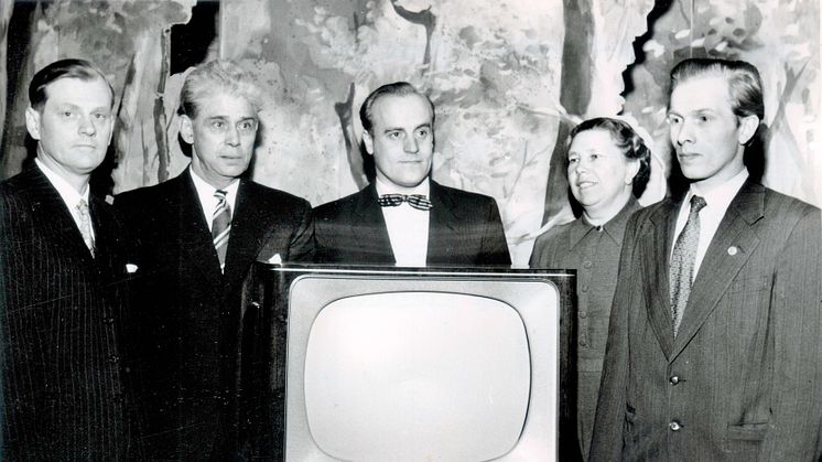 Det är den 11 mars 1957 och Högsjöpremiär för TV som aftonunderhållning. Styrelsen i Högsjö Arbetarekommun är samlad  kring TV–apparaten. Från vänster kassören Martin Olsson, .Erik Andersson, Lennart Wallin, Mery Axelsson och Göte Östlund.