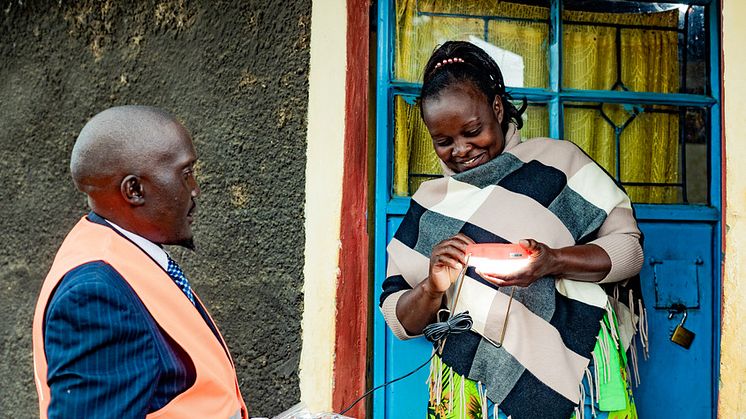 Erastus Ndaka from d.light delivers a solar-cell lamp to Redempta Nduva in Machakos, Kenya