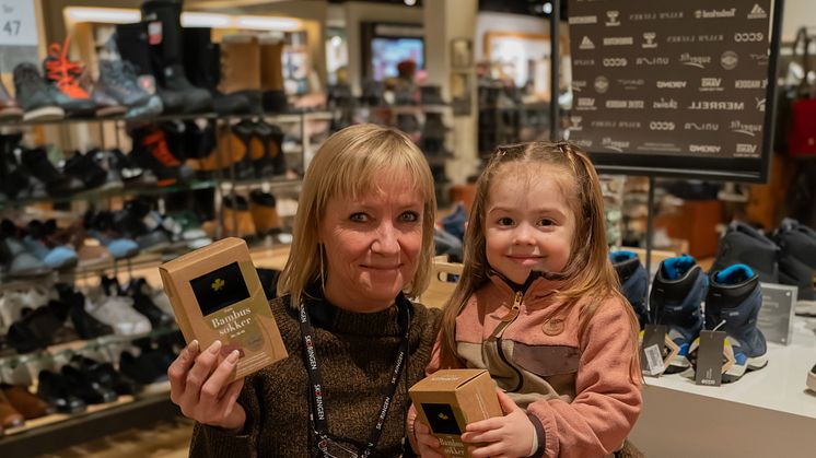 Butikkassistent Trine Hansen og hennes barnebarn Sophia i butikken i Tromsø, hvor kundene kjøpte 209 pakker bambussokker for samtidig å støtte Barnekreftforeningen.