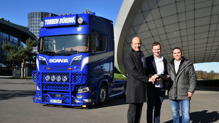 Stephan de Haar (li.), Leiter Erlebniswelten der Autostadt in Wolfsburg und Lars Rehberg (re.), Verkauf Neufahrzeuge Scania, gemeinsam mit Torben Döring, Geschäftsführer der Spedition Torben Döring, bei der ersten Lkw-Übergabe in der Autostadt.