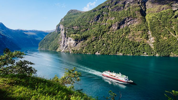 HÅPER PÅ JUNI-START: Hurtigruten håper å gradvis starte seilinger igjen fra juni. Her er MS Nordlys i sommervakre Geirangerfjorden. Foto: AGURTXANE CONCELLON/Hurtigruten