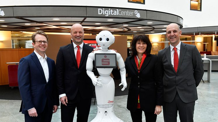 (v.li.) Dr. Bernd Hochberger, Ralf Fleischer, Marlies Mirbeth und Stefan Hattenkofer mit Roboter "Monaco Pepper" im neu eröffneten Digital-Center der Stadtsparkasse München.