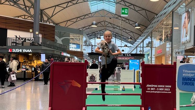 9 åriga Minna Stigsson flyger över Jönköping Horse Show hindret på Asecs tillsammans med sin käpphäst