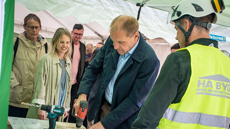 Fredrik Millertson, vd på LKF, borrar nya hem under spadtaget. De 40-tal besökare fick borra hål i insektshotellen som kommer följa med på hela byggresan och slutligen sättas upp vid inflyttningen år 2024.