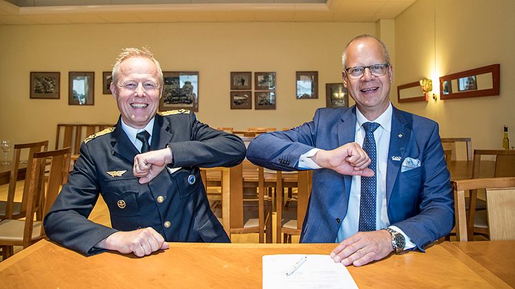 Flygvapenchefen Generalmajor Carl-Johan Edström och Stefan Oscarsson, Customer Director Government & Space GKN Aerospace, gör ett coronasäkert "handslag" vid signeringen av PBL-kontraktet.