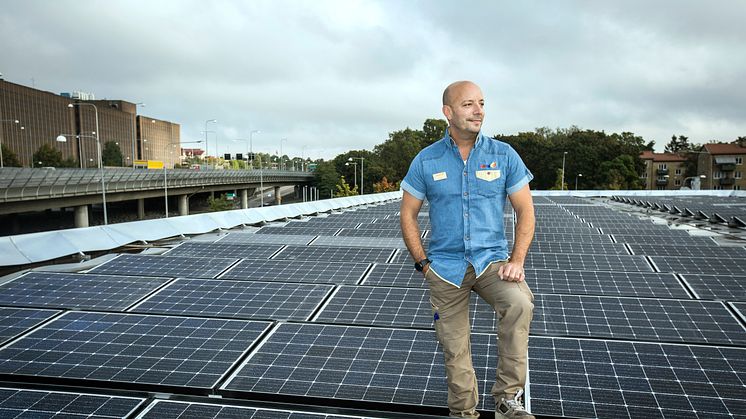 Säljchef Martin Garmstedt på OKQ8 Västberga står på stationens tak där solcellsanläggningen är installerad 