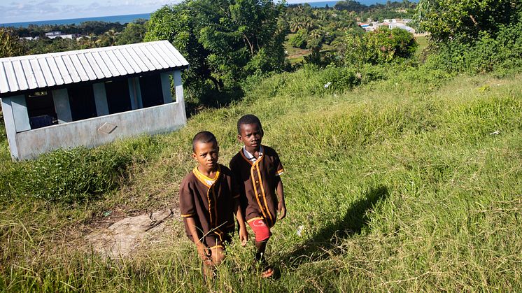 Jeudi och Juliano, 9 år, går uppför slänten från en av toalettanläggningarna på deras skola i Madagaskar. På skolan går 840 barn och det finns fem toaletter. Dock är flera ofta avstängda på grund av vattenbrist. Foto: Ernest Randriarimalala/WaterAid