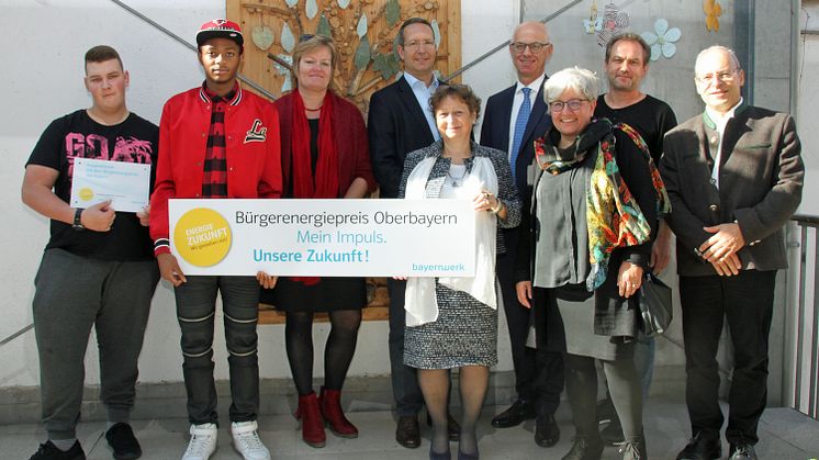 Zum Auftakt in der Mathilde-Eller-Schule stellten Regierungsvizepräsident Walter Jonas (3.v.r.) und Ingo Schroers, Leiter Kommunalmanagement (4.v.r.), den Bürgerenergiepreis Oberbayern beim Vorjahressieger in München vor.