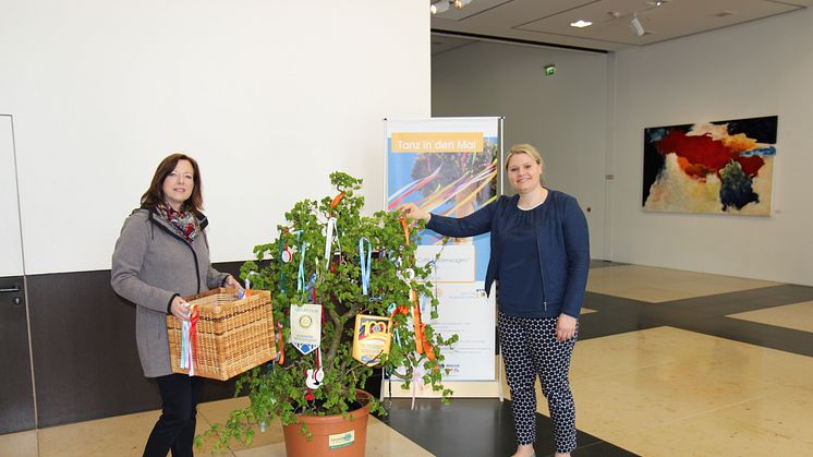 Sabine Neujahr (Lions Club Corona) und Martina Seidel (Barmenia) schmücken den Maibaum in der Barmenia