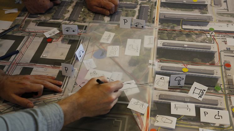 Workshop participant sketching on a design proposal for a shared space in a residential area. Photo: Bo Westerlund