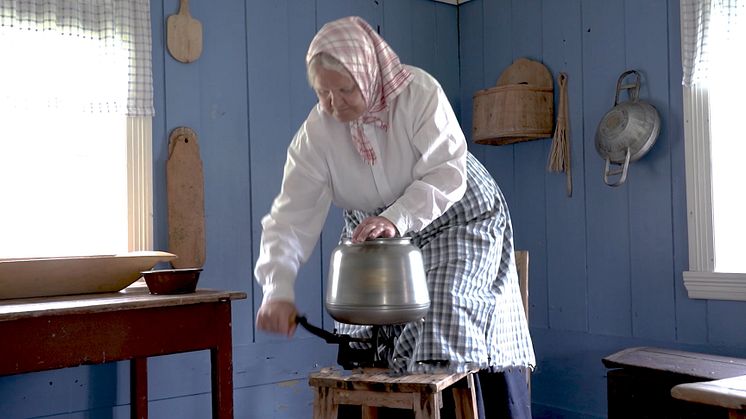 Anno Odalstunet formidler bruk av gjenstandene i museets samling. Birgitta Andreassen demonstrerer kjerning (kjinning) av smør. Foto: Anna Løvlund