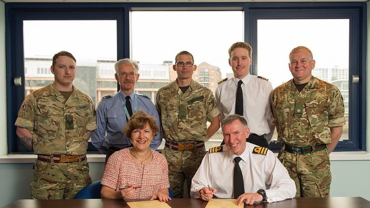 Lucy Winskell OBE from Northumbria signing the Armed Forces Covenant with Commander Ian Berry MBE RD RNR on HMS Calliope