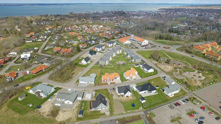 Montage med illustration av området med kvarteret BoKlok Smaragden i mitten, Färjestaden. 