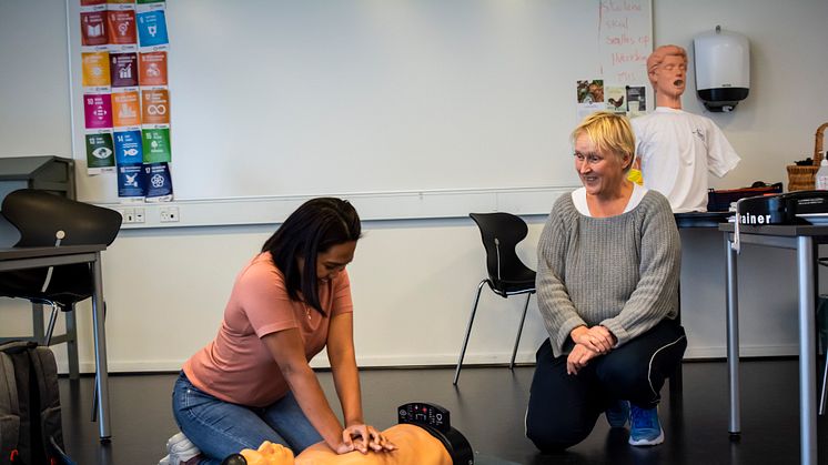 Tina Miller (th.) instruerer en af eleverne på Tradium i førstehjælp på en af de nyindkøbte træningsdukker.