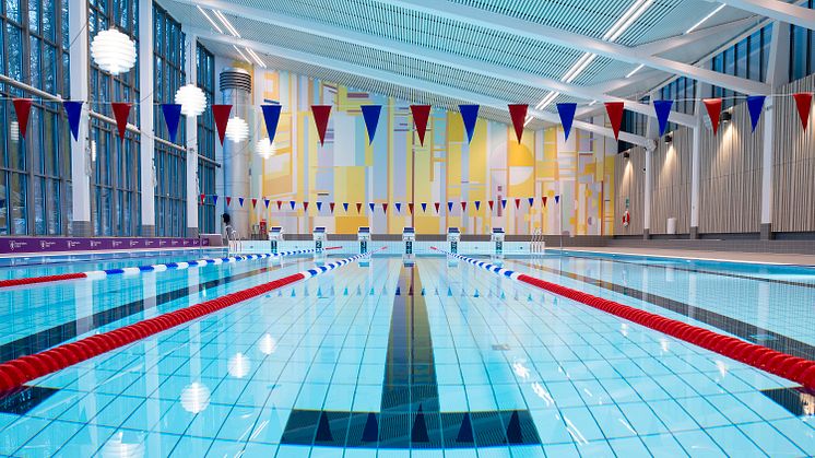 Åkeshovs sim- och idrottshall. Den helt återställda 25-meters bassängen samt fondmålning av av konstnären Lasse Andréasson.