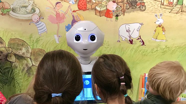 Barn bekantar sig med läsroboten Bibi på Skärholmens bibliotek