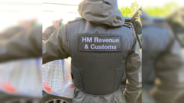 An HMRC officer seizes evidence, following a coordinated operation across England into large-scale tax repayment fraud (MND)