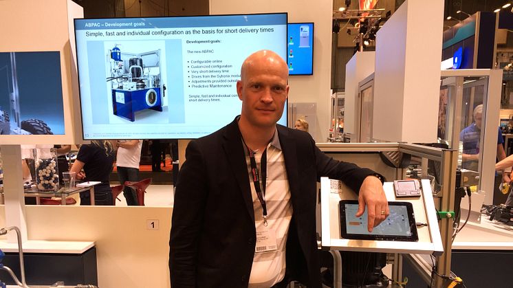 Jens Lindfeldt visar en hydraulpump med Condition Monitoring i bakgrunden.