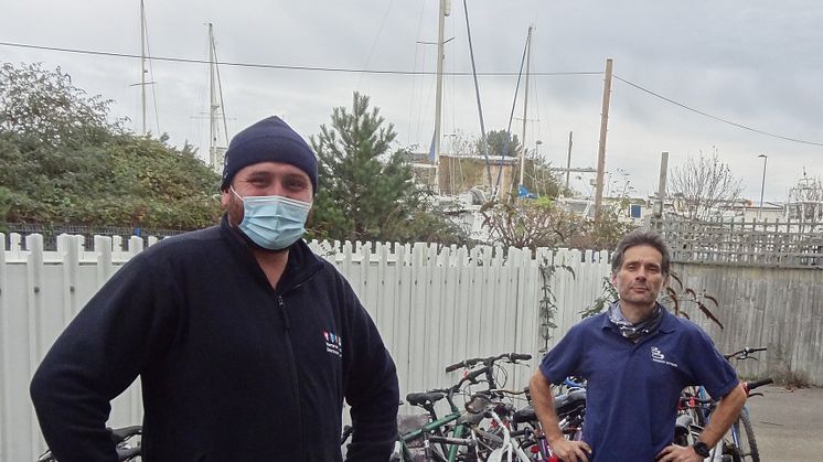 Wheels for wellness: Southern's Dylan Lohman (left) delivers 25 left-behind bikes to Bicycle Technician Paul Horta-Hopkins at SCDA's Newhaven recycling workshop