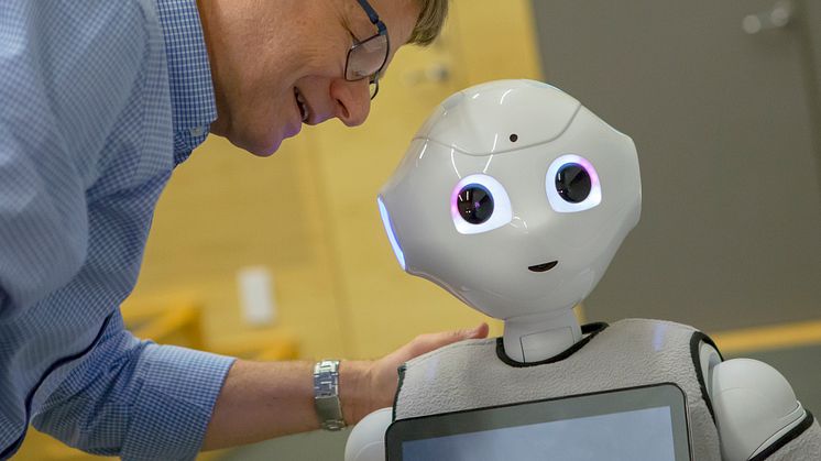 Paul Hemeren, prefekt och lektor i kognitionsvetenskap, vid Högskolan i Skövde tillsammans med roboten Pepper. Foto: Suss Wilén, Högskolan i Borås.