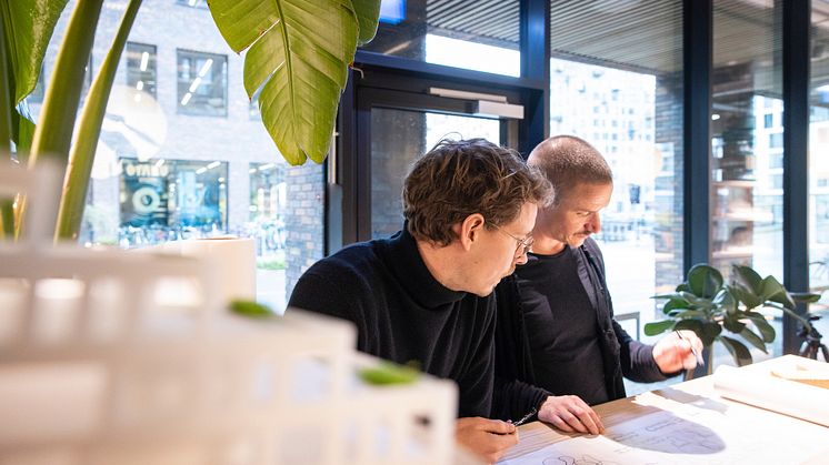 Det nye byrum- og landskabsteam sidder til dagligt i AARTs kontor i Pakhusene på Aarhus Ø. På billedet ses faglig leder Jens Byriel Kinch (th.) i skitserende dialog med en kollega.