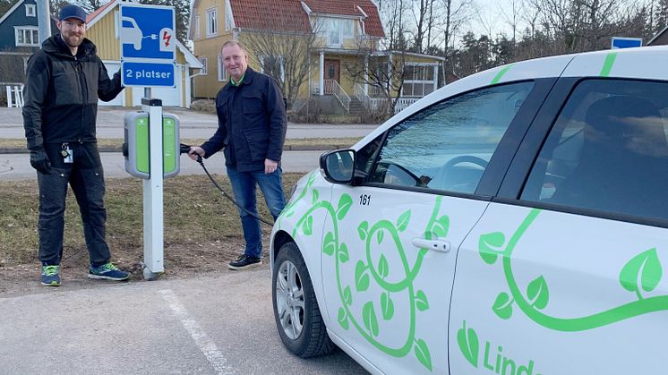 Nils Jonsén-Skanebo, sekreterare Brf Boken, och Richard Järlstam, marknads- och försäljningschef på Linde energi, framför en av Brf Bokens två laddstolpar.