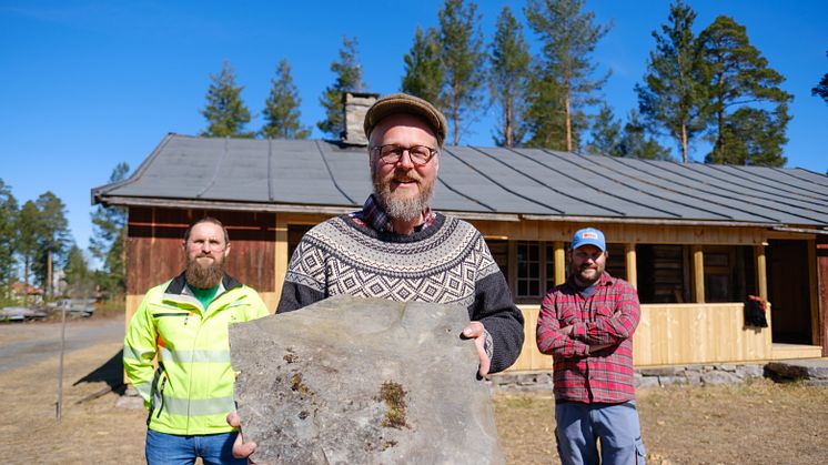 TRENGER SKIFER: Håndverker Sveinung Sletten viser med et stykke skifer som skal opp på taket på Staistua på Anno Glomdalsmuseet. Bak står driftssjef Ivar Busterud Bjørnstad (t.v.)og håndverker Henrik Josefsson. (Foto: Ali Suliman/Anno)