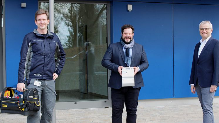 Michael Schindler (l.) und Stephan Leibl (r.) von der Bayernwerk Netz haben mit Bürgermeister Raffael Parzefall in der Grundschule Thalmassing einen intelligenten Zähler montiert. Deutschlandweit im E.ON-Konzern ist es der 100.000 Smart Meter.