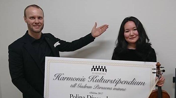 Manskören Harmonis kulturstipendium 2017 gick till Polina Djusembeyeva som här gratuleras av körens dirigent Rickard Larsson.