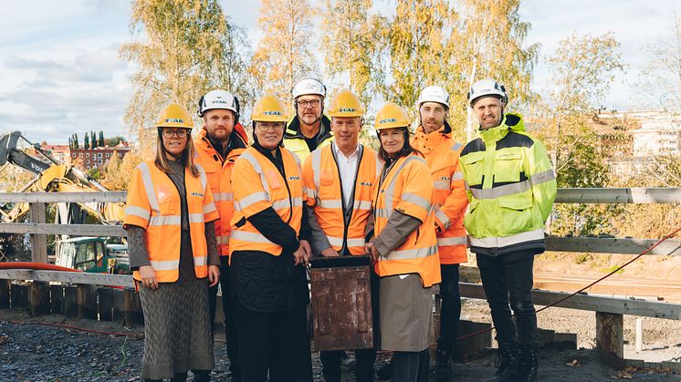 Representanter från Skellefteå kommun, Arctic Center of Energy och Peab håller i tidskapseln på byggplatsen för ACE-huset. Foto: Jonas Westling. 