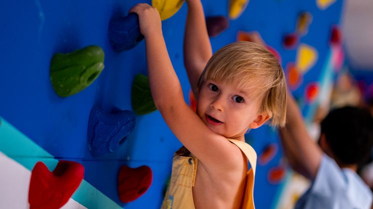 A toddler using the Boulder Wall during a Rock Tots session