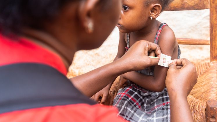 CH1838505_Rose Nalda measures Withmaly's arm for signs of malnutrition