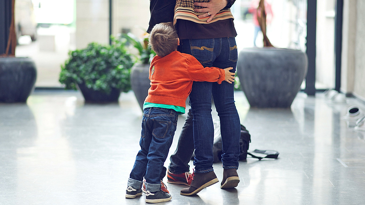 Barn kramar föräldrars ben. Foto: Petter Johansson