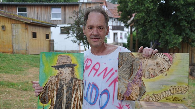 Udo-Lindenberg-Fan Jörg Ernst Brück in seinem Lieblings-T-Shirt zeigt zwei seiner in Holzbrandtechnik geschaffenen Bilder von „Panik-Udo“ und Keith Richards.