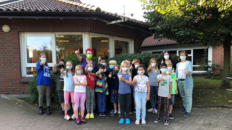 Umweltclownin Ines Hansen (hinten Mitte) und Kleckens Ortsbürgermeisterin Anke Grabe (r.) zu Besuch in der Grundschule Klecken.