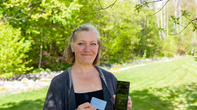 Anita Vasstveit med sitt første utfylte Donorkort™ og den nyeste appen på telefonen.