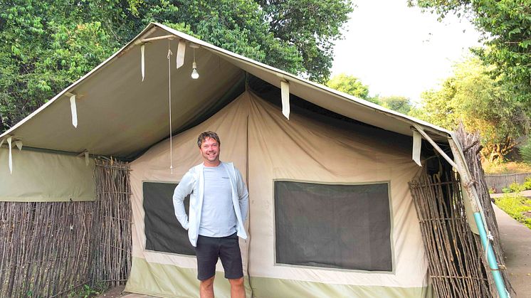 Verksamhetschefen Jonas Sommar framför ett tält i viltreservatet Masai Mara.