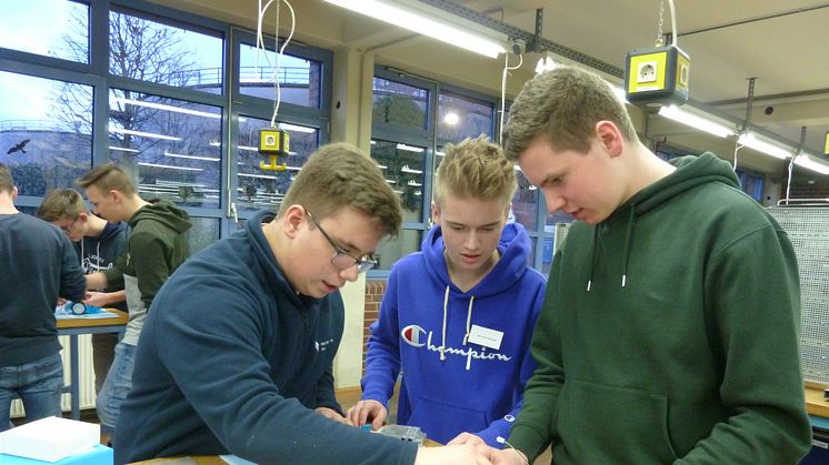 WWE- Azubi Jan Niklas Heidemann, Finn Levin Schmude und Mathis Stratmann vom Delbrücker Gymnasium bauen beim Energy Camp einen Mini-Roboter in der Ausbildungswerkstatt. (v. l.).