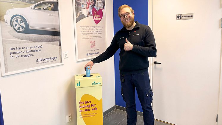 Besiktningstekniker Elliot Albertson på Bilprovningen i Sollentuna pantar en burk till förmån för Friends.   Foto: Bilprovningen