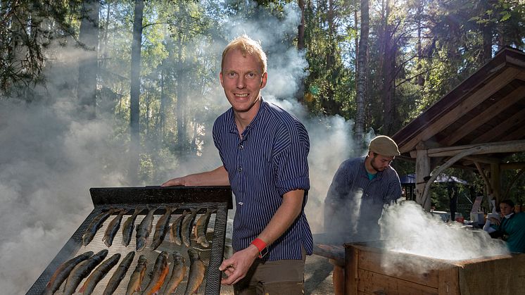 Fiskerøyking er et tradisjonsrikt innslag som bokstavelig talt faller i smak hos gjestene på De nordiske jakt- og fiskedagene. Erik Burud er røykemester. (Foto: Bård Løken/Anno Norsk skogmuseum)