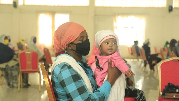 Zenebech* mother of three with her youngest at an emergency food assistance gathering.