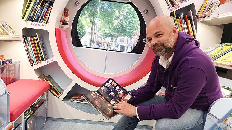 Mediepedagog Olof Wadell sitter i bokbussen "Farkosten" och berättar om besöket på Gårdstensdagen. Foto: Malin Bülling.