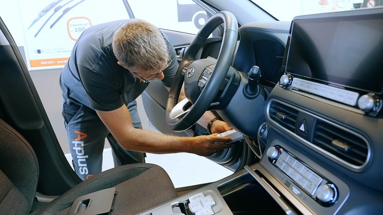 En bilsagkyndig hos Applus+ Bilsyn monterer en såkaldt 'dongle', som bruges til at måle en elbils batteri, og kort efter foreligger resultatet.