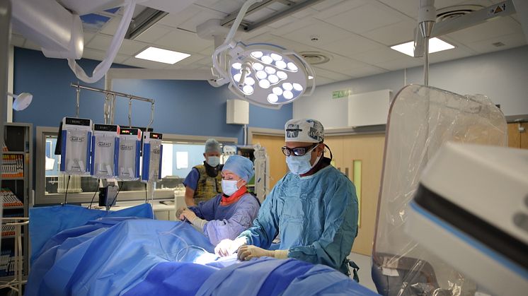 Radiologist, nurse and interventional neuroradiologist conduct a mechanical thrombectomy on a patient