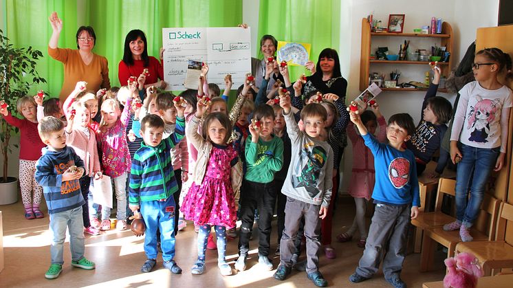 Große Aufregung während der Spendenscheckpräsentation: Stolz halten die Kinder ihr Herzbärchen in die Höhe