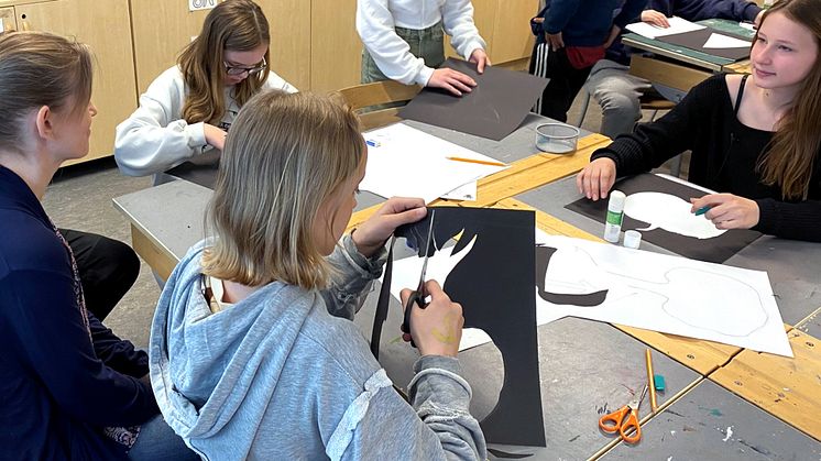 Elever på Stavsborgsskolan tar fram motiv till gamla stenplattor som ska återanvändas på den nya skolans gård.   